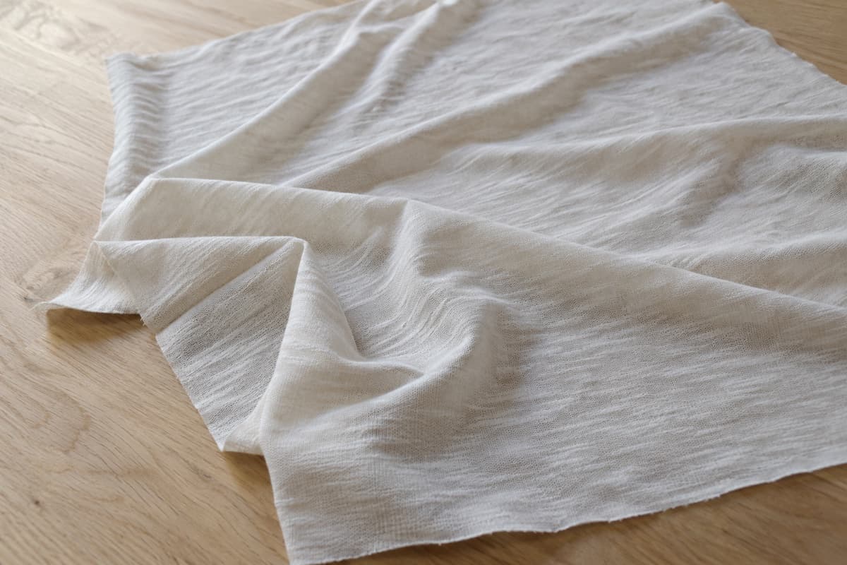 ภาพประกอบผ้า Cotton Slub (ผ้าผสม) ทั้งผืนพับมุม ให้เห็นความหนาและการทิ้งตัวของผ้าเสื้อยืด