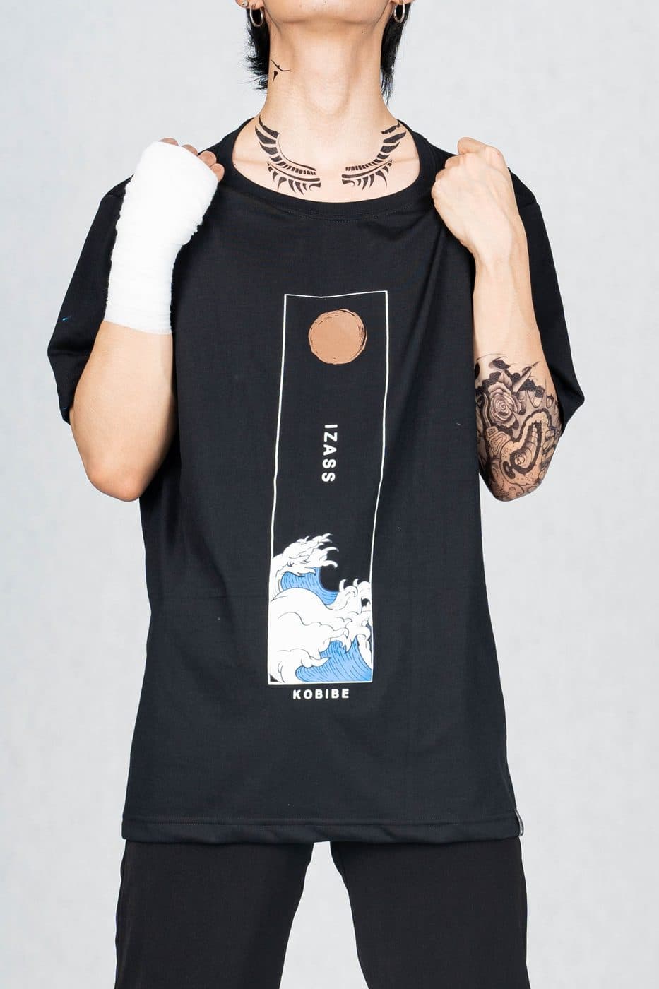 นายแบบใส่เสื้อยืดสีดำ สกรีนลายกรอบแนวตั้งพระอาทิตย์และคลื่น