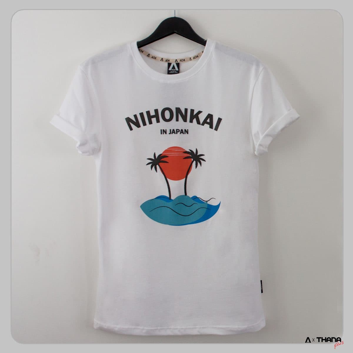 เสื้อยืดสีขาวแขวนบนไม้แขวน สกรีนลายเกาะปาล์มหลายสี