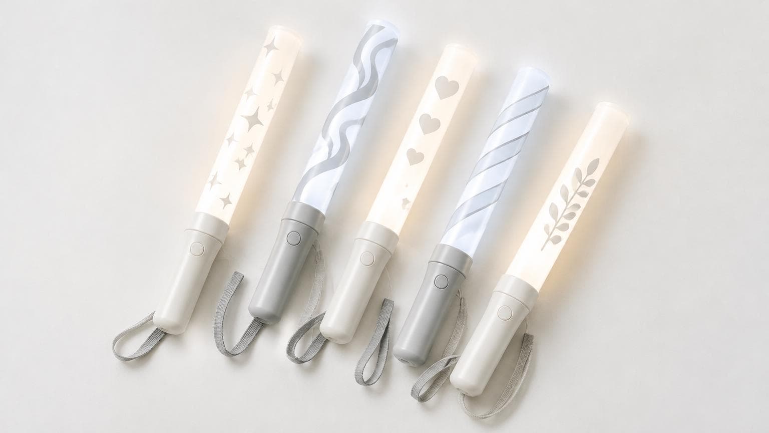 แท่งไฟ LED หลายแท่งวางเรียงบนพื้นสีขาว ใช้เป็นแท่งไฟสกรีนโลโก้แจกงานบริษัท