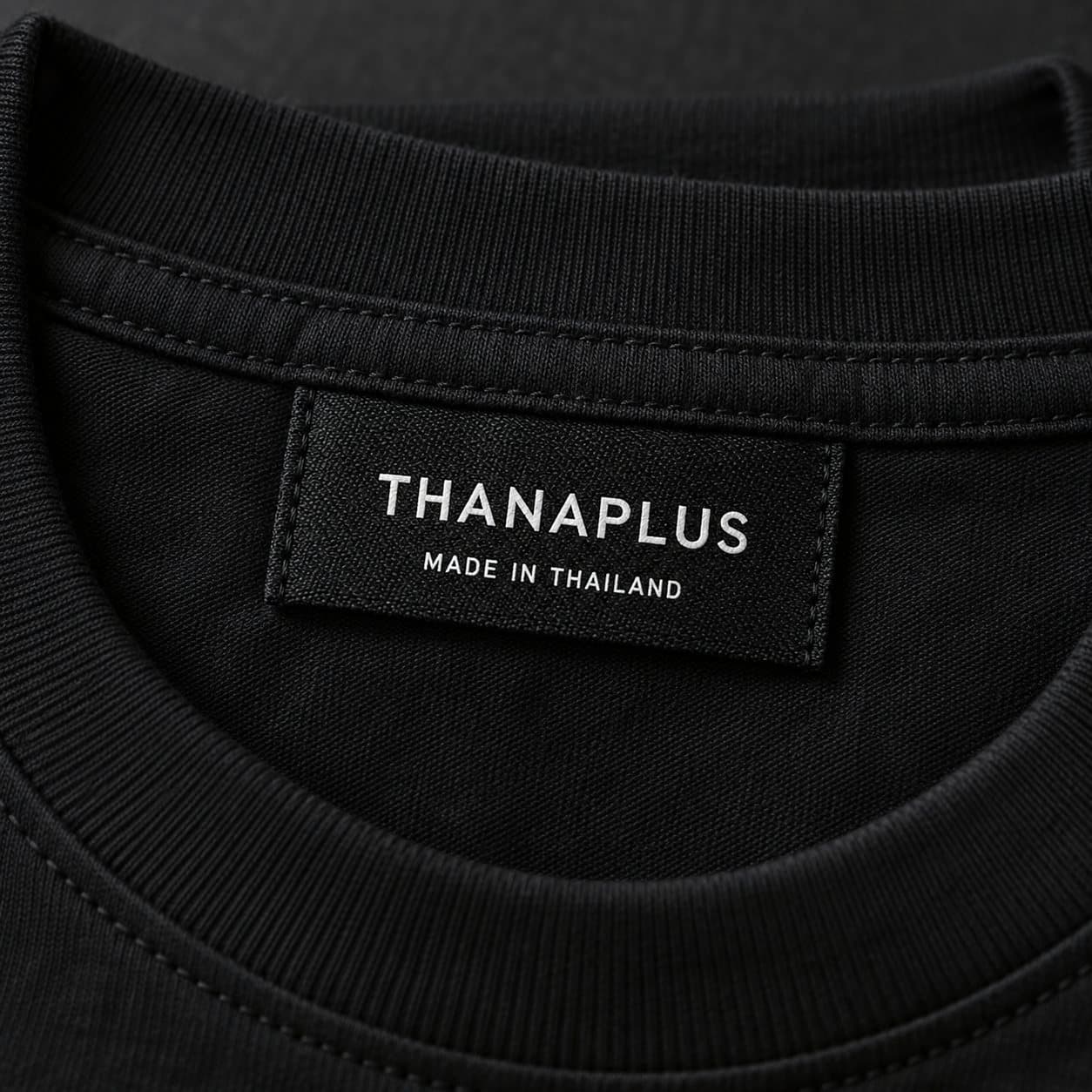 ป้ายคอทอ THANAPLUS บนเสื้อยืดสีดำ