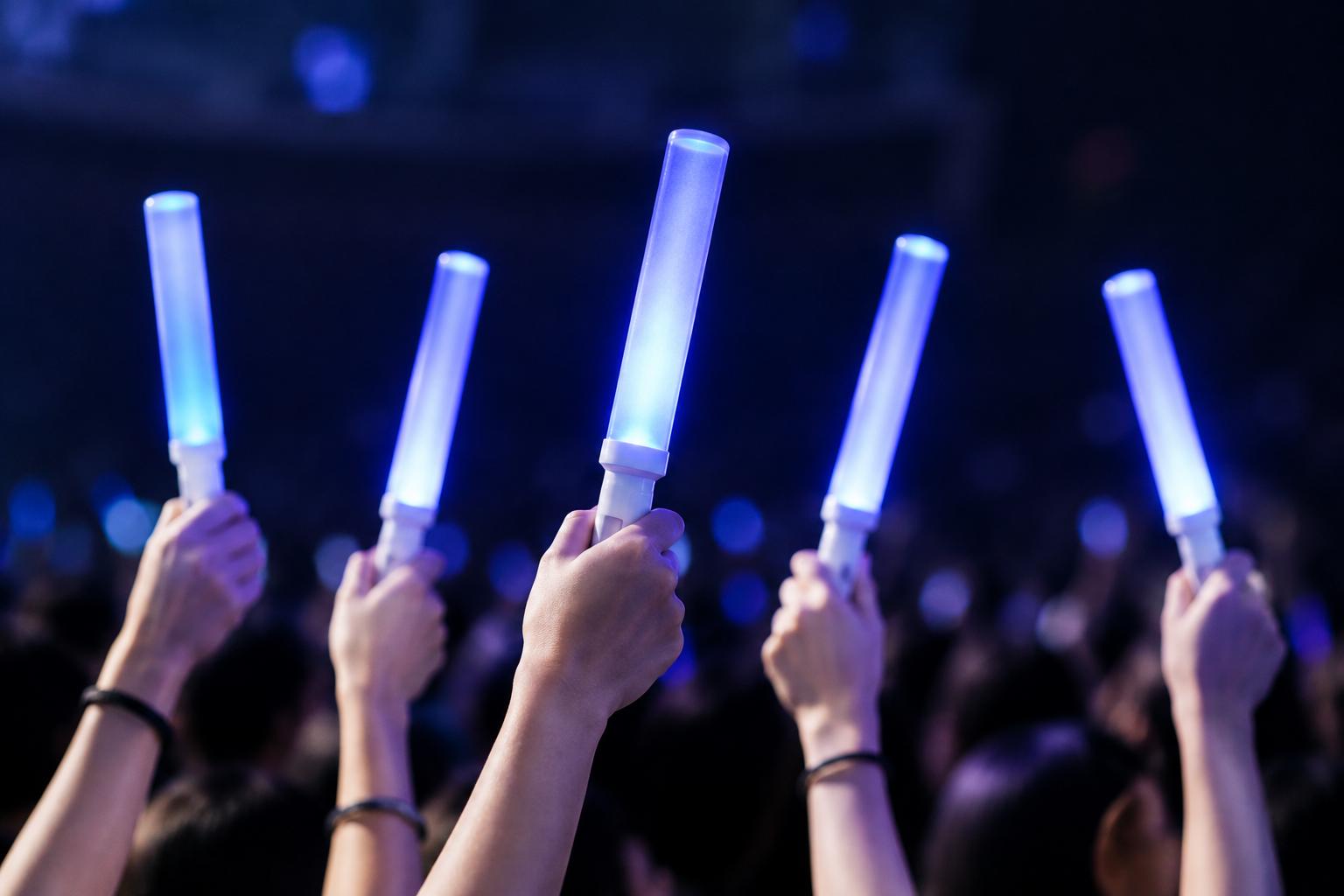 กลุ่มคนยกแท่งไฟ LED สีเดียวกันขึ้นพร้อมกันในงานอีเวนต์ ภาพรวมเป็นหนึ่งเดียว